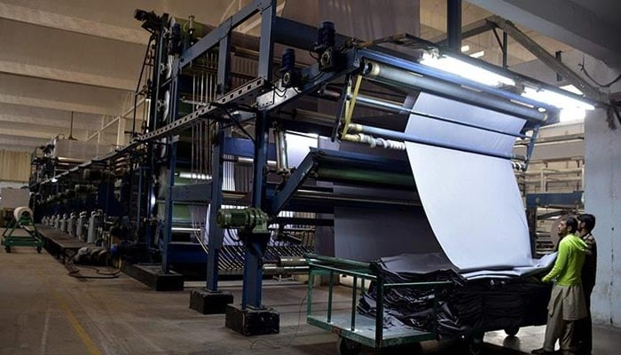 Pakistani workers operate a machine at a textile factory in Faisalabad. Image used for representaiton only— AFP/File