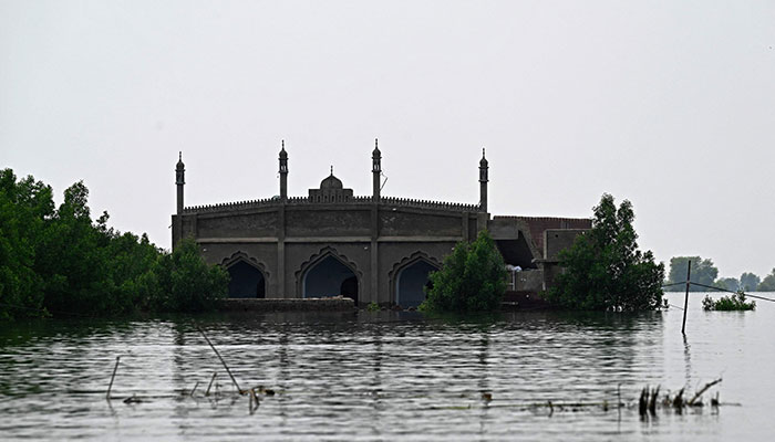 7 ستمبر 2022 کو صوبہ سندھ کے ضلع دادو میں مون سون کی شدید بارشوں کے بعد ایک چھوٹے سے پاکستانی گاؤں بستی احمد دین میں سیلاب زدہ مسجد کی تصویر ہے۔ — اے ایف پی