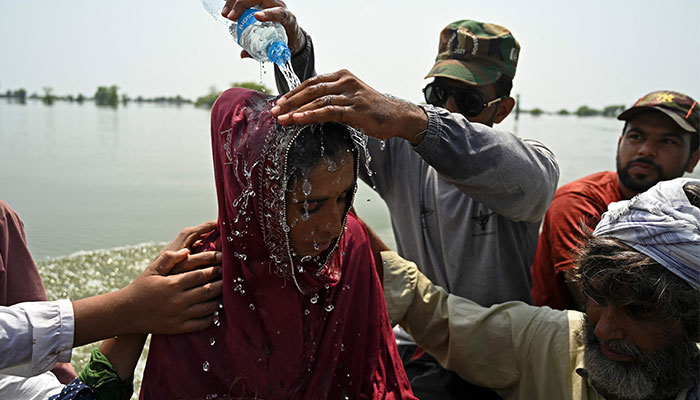 A Pakistan´s Navy personnel helps a stranded patient in a boat after rescuing from her flooded house at Basti Ahmad Din, a tiny Pakistani village after heavy monsoon rains in Dadu district, Sindh province on September 7, 2022. — AFP