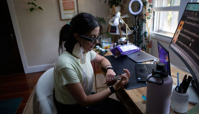 Lauren Nichols, who has long COVID, takes a break from work to read her blood oxygen levels and heart rate from a machine on her finger in her home in Andover, Massachusetts, US, August 3, 2022. — Reuters