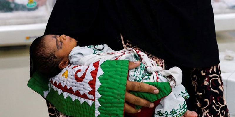 A mother carries her baby while waiting for medical assistance at a hospital, following rains and floods during the monsoon season in Sehwan, Pakistan September 7, 2022. — Reuters