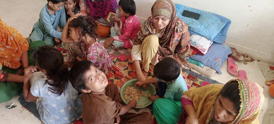 A child looks up as he eats food in Khairpur, Sindh, following rains and floods during the monsoon season. — By Maria Mushtaq and Waheed Ali