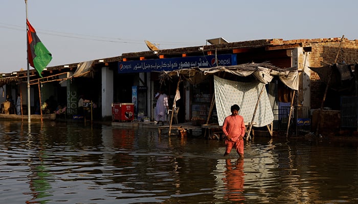 A man wades through flood water along a market, following rains and floods during the monsoon season in Bajara village, at the banks of Manchar lake, in Sehwan, Pakistan September 6, 2022. — Reuters