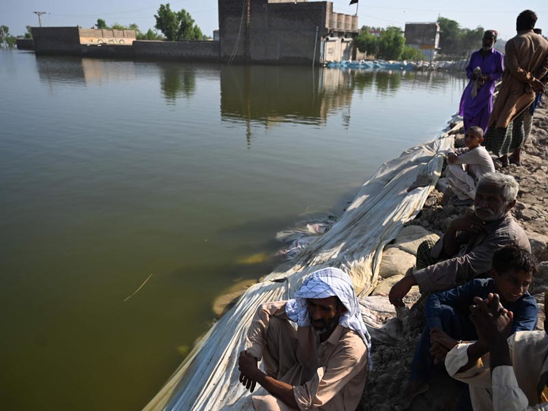 Flood-affected people gather by an embankment in Mehar city after heavy monsoon rains in Dadu district, Sindh province on September 9, 2022. — AFP