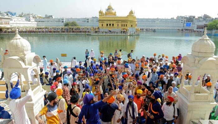 Indian Sikh activists hold swords and leaflets as they shout pro-Khalistan and anti-government slogans after prayers at the Golden Temple in Amritsar. — AFP