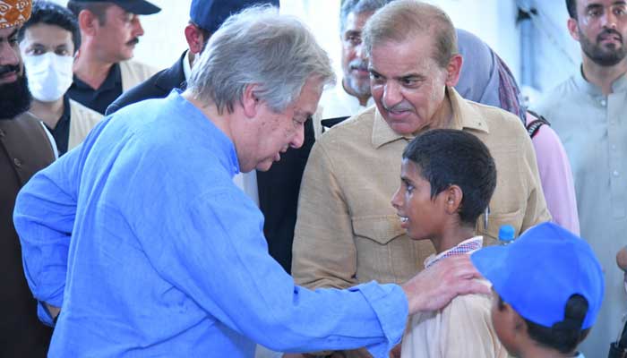 UN Secretary General Antonio Guterres interacts with a child at a relief camp set up for flood victims. Photo: Twitter/@CMShehbaz