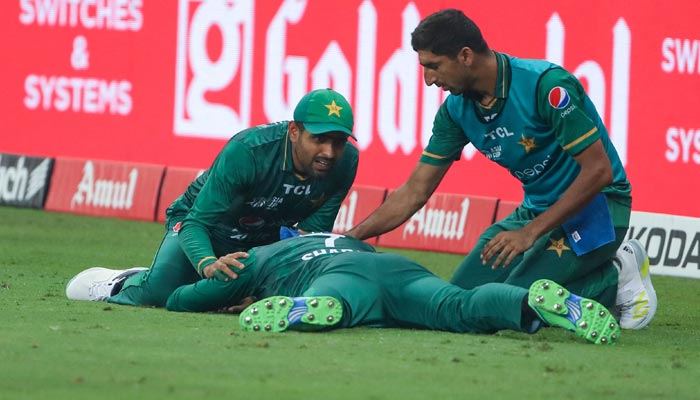 Pakistans captain Babar Azam (L) checks teammate Shadab Khan after he collided with Asif Ali in an attempt to take a catch during the Asia Cup Twenty20 international cricket final match between Pakistan and Sri Lanka at the Dubai International Cricket Stadium in Dubai on September 11, 2022. — AFP