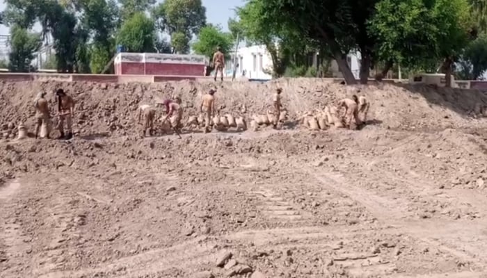 Soldiers are busy strengthening a dike built in front of the electricity station in Dadu, in September 2022, as they seek to save the station from floodwaters. — ISPR