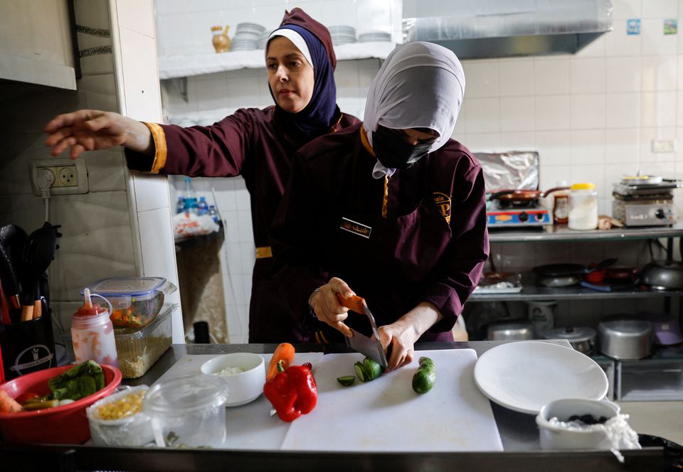 فلسطینی شیف آمنہ الحیک 6 ستمبر 2022 کو غزہ سٹی میں خواتین کے لیے نئے کھلے ہوئے ریستوران میں کھانا بنا رہی ہیں، جسے صابیہ وی آئی پی کہا جاتا ہے۔ — رائٹرز