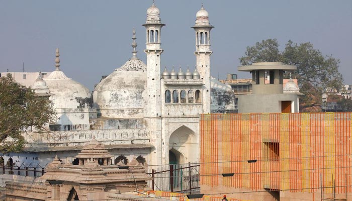 A worker stands on a temple rooftop adjacent to the Gyanvapi Mosque ahead of the inauguration of the new Kashi Vishwanath Temple corridor by Indias Prime Minister Narendra Modi in the northern city of Varanasi, India, December 12, 2021. — Reuters