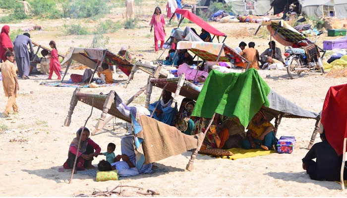 Flood-affected families are sitting at a flood relief camp in Jamshoro. APP