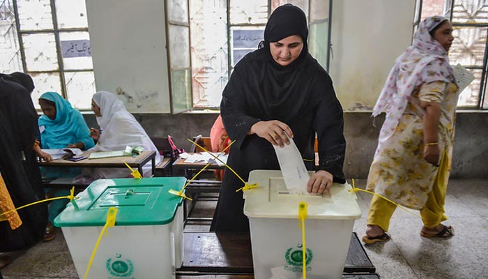 A woman casts her vote during Pakistans general election at a polling station during the general election in Lahore, Pakistan, on July 25, 2018. — AFP