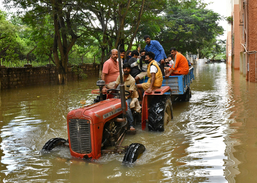 Residents are evacuated to safer places in a tractor trolley after heavy rains caused flooding in a residential area in Bengaluru, India, November 22, 2021. — Reuters