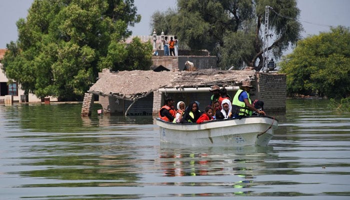 Rescued flood victims sit in a boat, following rains and floods during the monsoon season in village Arazi, in Sehwan, Pakistan, September 11, 2022. — Reuters