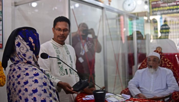 Ferdousi Begum (L) describes her symptoms to Sufi leader Syed Emdadul Hoque (R) at the Maizbhandar Darbar Sharif shrine in Maizbhandar. Evil spirits bedevil the families that seek blessings from an elderly Bangladeshi mystic -- but he knows that his prayers alone are not enough to soothe their troubled minds.