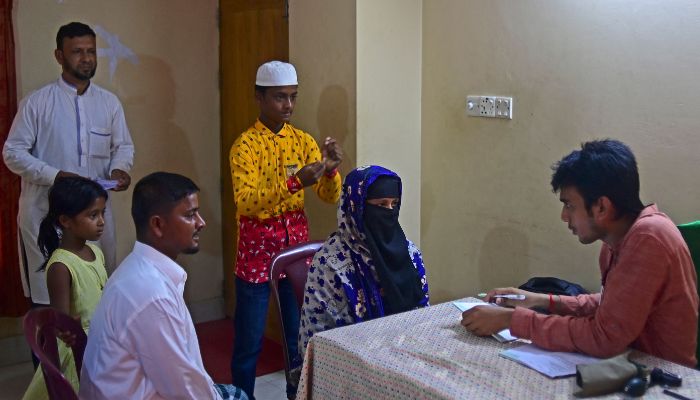 Ferdousi Begum (2R) talks to a psychiatrist (R) at the Maizbhandar Darbar Sharif shrine in Maizbhandar. Evil spirits bedevil the families that seek blessings from an elderly Bangladeshi mystic -- but he knows that his prayers alone are not enough to soothe their troubled minds.