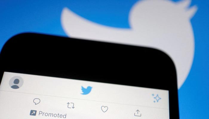 A promoted tweet on Twitter app is displayed on a mobile phone near a Twitter logo, in this illustration picture taken Sept. 8, 2022. — Reuters/File