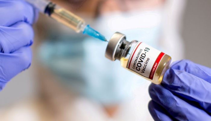 A woman holds a small bottle labelled with a Coronavirus COVID-19 Vaccine sticker and a medical syringe in this illustration taken October 30, 2020. — Reuters