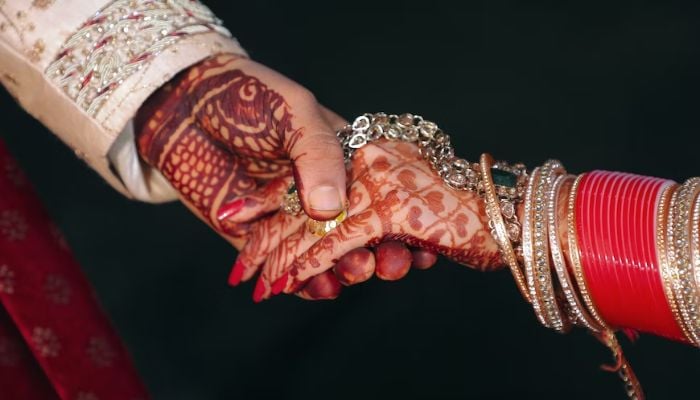 An groom holding a brides hand. — Unsplash