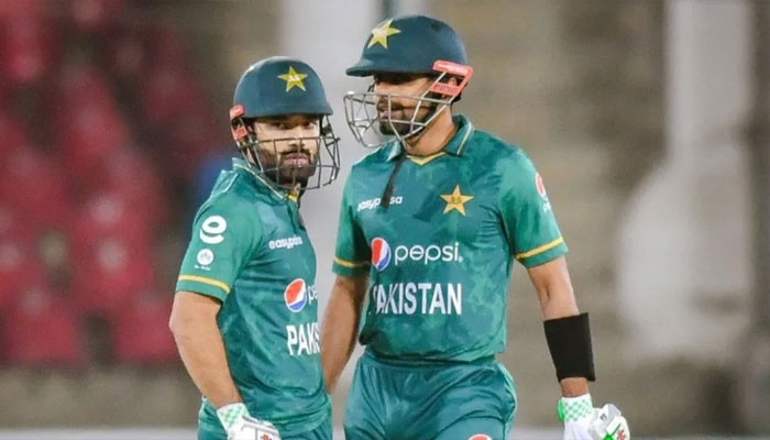 Mohammad Rizwan (left) and Babar Azam seen discussing strategy amid a cricket match. — PCB