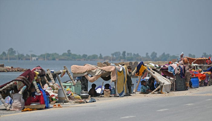 Internally displaced flood-affected people shelter in makeshift tents along a road in higher ground in flooded area after heavy monsoon rains on the outskirts of Jacobabad, Sindh province, on September 6, 2022. —AFP