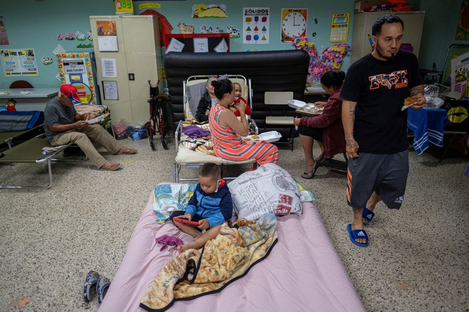 جن لوگوں کو ان کے گھروں سے نکالا گیا تھا وہ 18 ستمبر 2022 کو گوانیلا، پورٹو ریکو میں سمندری طوفان فیونا اور اس کی شدید بارشوں کے قریب پہنچنے پر ایک سرکاری اسکول کے کلاس روم میں پناہ گاہ میں نظر آئے۔
