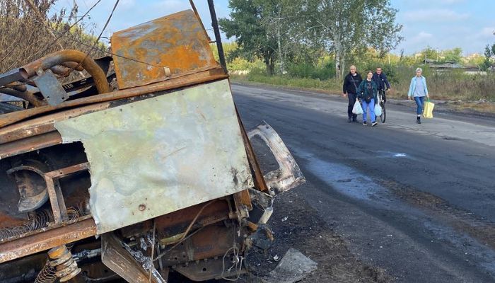 Nataliia Yelistratova with her husband Mykhailio and daughter Olena Miroshnychenko walk along a street past a destroyed military vehicle in their hometown of Balakliia, which was recently liberated by the Ukrainian armed Forces, amid Russias attack on Ukraine, in Kharkiv region, Ukraine September 17, 2022. — Reuters