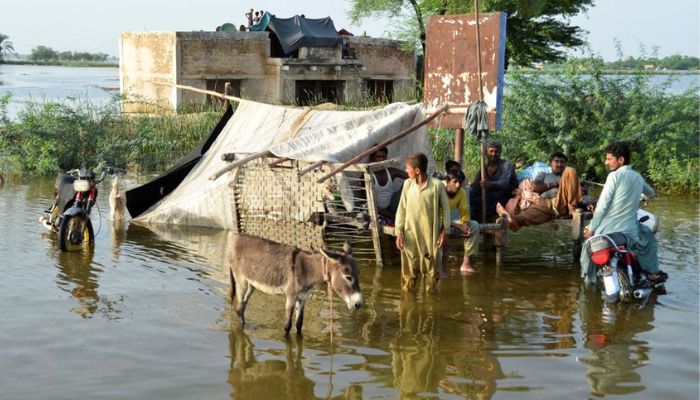 People are seen outside their flooded house, following rains and floods during the monsoon season in Sohbatpur, Pakistan August 28, 2022. — Reuters