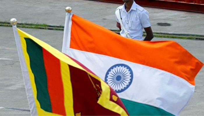 A Navy officer stands in front of Indias and Sri Lankas national flags as Indian Coast Guard Ship (ICGS) Shoor is in the Colombo port during its visit in Colombo, Sri Lanka April 2, 2018. — Reuters