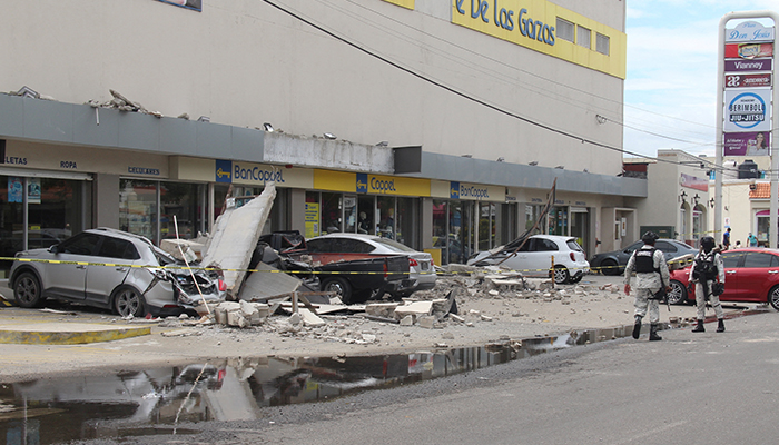Anggota Garda Nasional berdiri di dekat kendaraan yang rusak akibat runtuhnya fasad department store saat gempa bumi, di Manzanillo, Meksiko 19 September 2022. — Reuters