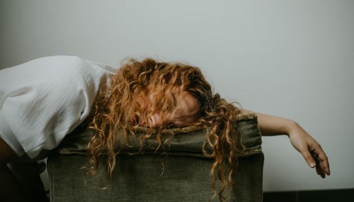 A sad woman lying on the couch. — Unsplash