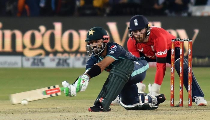 Pakistans Mohammad Rizwan (L) plays a shot as Englands wicketkeeper Phil Salt watches during the first Twenty20 international cricket match between Pakistan and England at the National Cricket Stadium in Karachi on September 20, 2022. — AFP