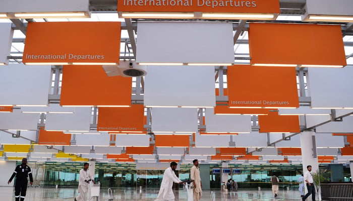 Workers move luggage trolleys at the Islamabad International Airport in this undated photo. — AFP/File