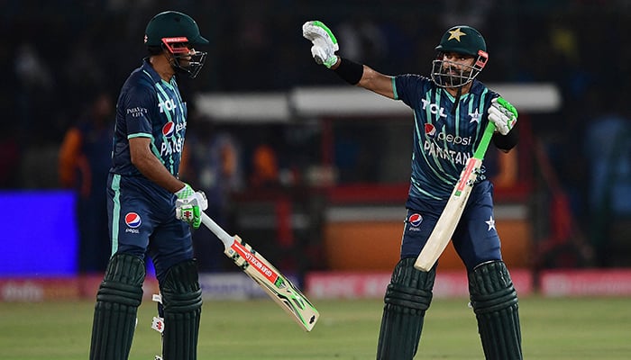 Pakistans Mohammad Rizwan (R) celebrates after scoring a half-century (50 runs) as captain Babar Azam looks on during the first Twenty20 international cricket match between Pakistan and England at the National Cricket Stadium in Karachi on September 20, 2022. — AFP