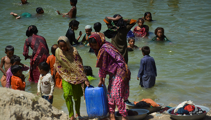 People, displaced because of the floods, carry a canister filled with flood water while taking refuge in a camp, following rains and floods during the monsoon season in Sehwan, Pakistan September 20, 2022. — Reuters