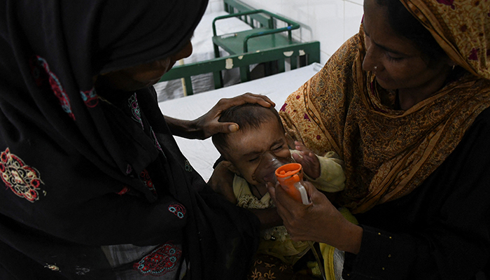 سیلاب کی وجہ سے بے گھر ہونے والی خواتین، 20 ستمبر 2022 کو پاکستان کے جامشورو میں مون سون کے موسم کے دوران بارشوں اور سیلاب کے بعد، ہسپتال میں ایک بیمار بچے کی دیکھ بھال کر رہی ہیں۔ — رائٹرز
