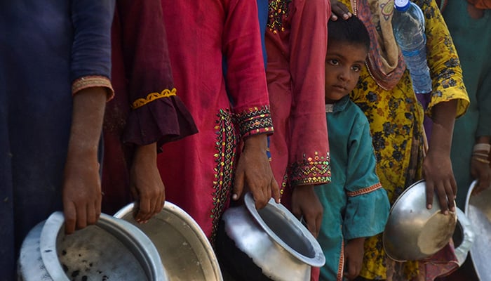 People, displaced because of the floods, gather to receive food handout in a camp, following rains and floods during the monsoon season in Sehwan, Pakistan September 20, 2022. — Reuters