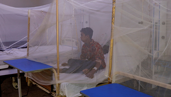 A patient suffering from dengue fever sits under a mosquito net inside a dengue and malaria ward at the Sindh Government Services Hospital in Karachi, Pakistan September 21, 2022. — Reuters