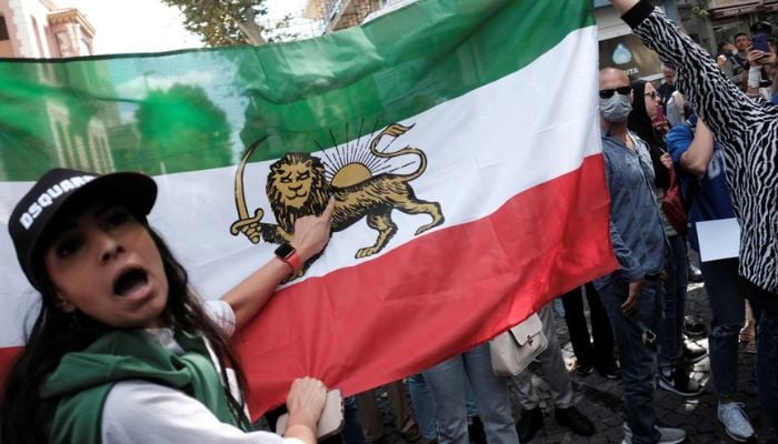 An Iranian woman living in Turkey points at an old Iranian royal flag during a protest following the death of Mahsa Amini, outside the Iranian consulate in Istanbul, Turkey September 21, 2022. —  Reuters