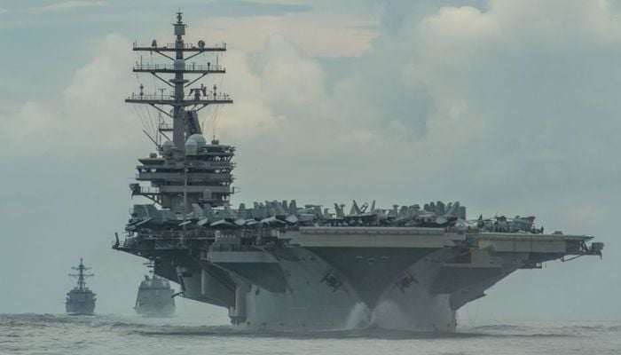 From right, the Nimitz-class aircraft carrier USS Ronald Reagan (CVN 76), the Japan Maritime Self-Defense Force Akizuki-class destroyer JS Teruzuki (DD 116) and the Arleigh Burke-class destroyer USS Mustin (DDG 89) sail in formation in the Philippine Sea, July 19, 2020. Picture taken July 19. 2020.— Reuters