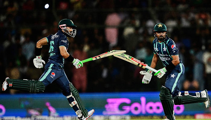 Pakistans captain Babar Azam (R) and teammate Mohammad Rizwan run between the wicket during the second Twenty20 international cricket match between Pakistan and England at the National Cricket Stadium in Karachi on September 22, 2022. — AFP