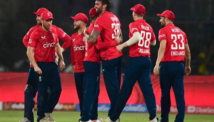 Englands Reece Topley (C) celebrates with teammates after taking the wicket of Pakistans Mohammad Rizwan (not pictured) during the third T20 international cricket match between Pakistan and England at the National Cricket Stadium in Karachi on September 23, 2022. — AFP