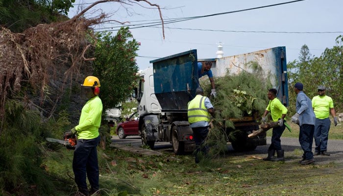 A work crew clears debris after high winds from Hurricane Fiona hit the south shore of Bermuda September 23, 2022. — Reuters