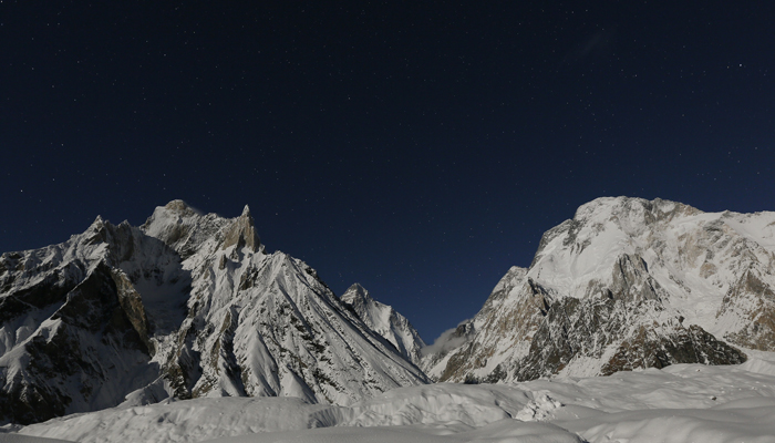 K2 (backdrop) and Broad Peak (right side), are illuminated by the moon at Concordia, the confluence of the Baltoro and Godwin-Austen glaciers, in the Karakoram mountain range in Pakistan on September 7, 2014. — Reuters