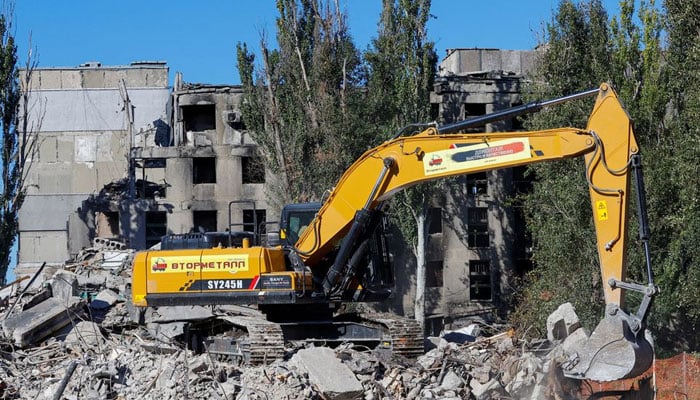 25 ستمبر 2022 کو یوکرین کے ماریوپول میں روس-یوکرین تنازعہ کے دوران تباہ ہونے والے اپارٹمنٹ بلاک کے ملبے کو ہٹاتے ہوئے ایک کارکن کھدائی کر رہا ہے۔ — رائٹرز