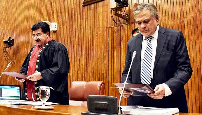 Senate Chairman Muhammad Sadiq Sanjrani administering oath to the newly elected Senator Muhammad Ishaq Dar during the senate session at Parliament House on September 27, 2022. — APP