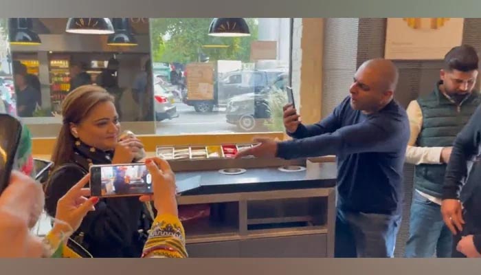 Minister of Information Marriyum Aurangzeb is harassed and filmed by PTI supporters inside a coffee shop in London. — Screengrab/Twitter