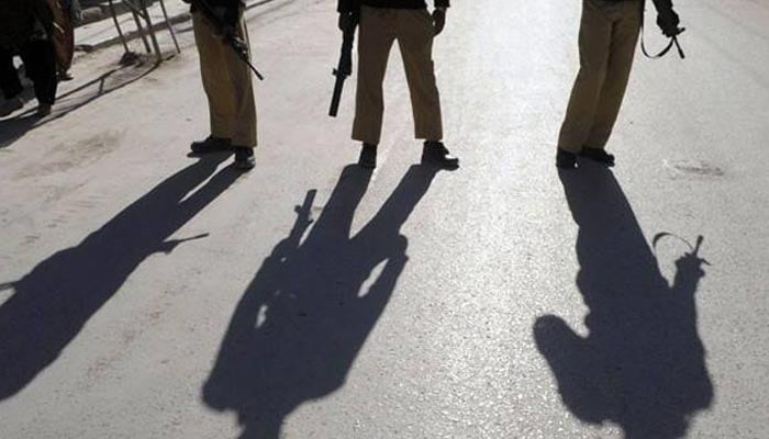 The picture shows policemen standing on a road. — AFP/ File