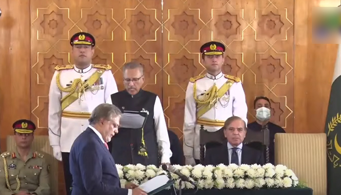 President Arif Alvi (centre left) administrates oath to the Senator Muhammad Ishaq Dar (below left) at Awan-e-Sadar in Islamabad on September 27, 2022. — Geo News