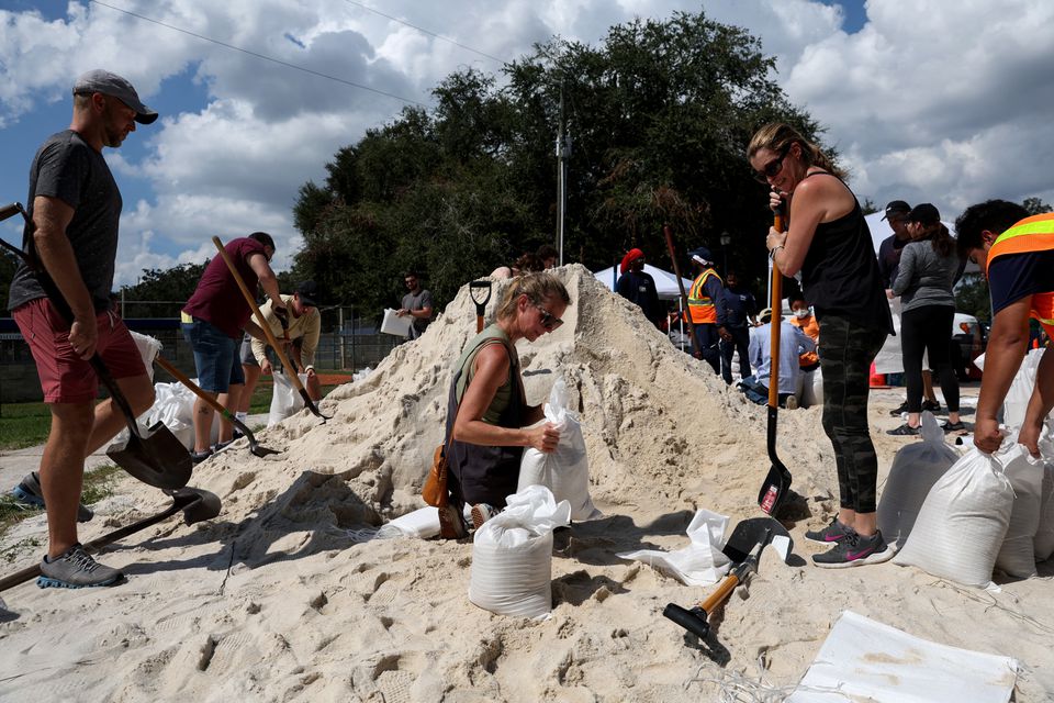 Local residents fill sandbags, as Hurricane Ian spun toward Florida carrying high winds, torrential rains and a powerful storm surge, at the Himes Avenue Complex in Tampa, Florida, U.S., September 26, 2022.  — Reuters